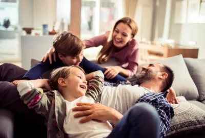 Family lays on couch and laughs inside of warm home in Southwest Chicago.