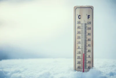 Thermometer in the snow showing freezing temperatures.